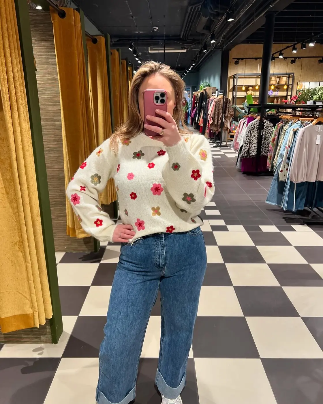 Een klant in een crèmekleurige bloementrui in de winkel van TamTam
